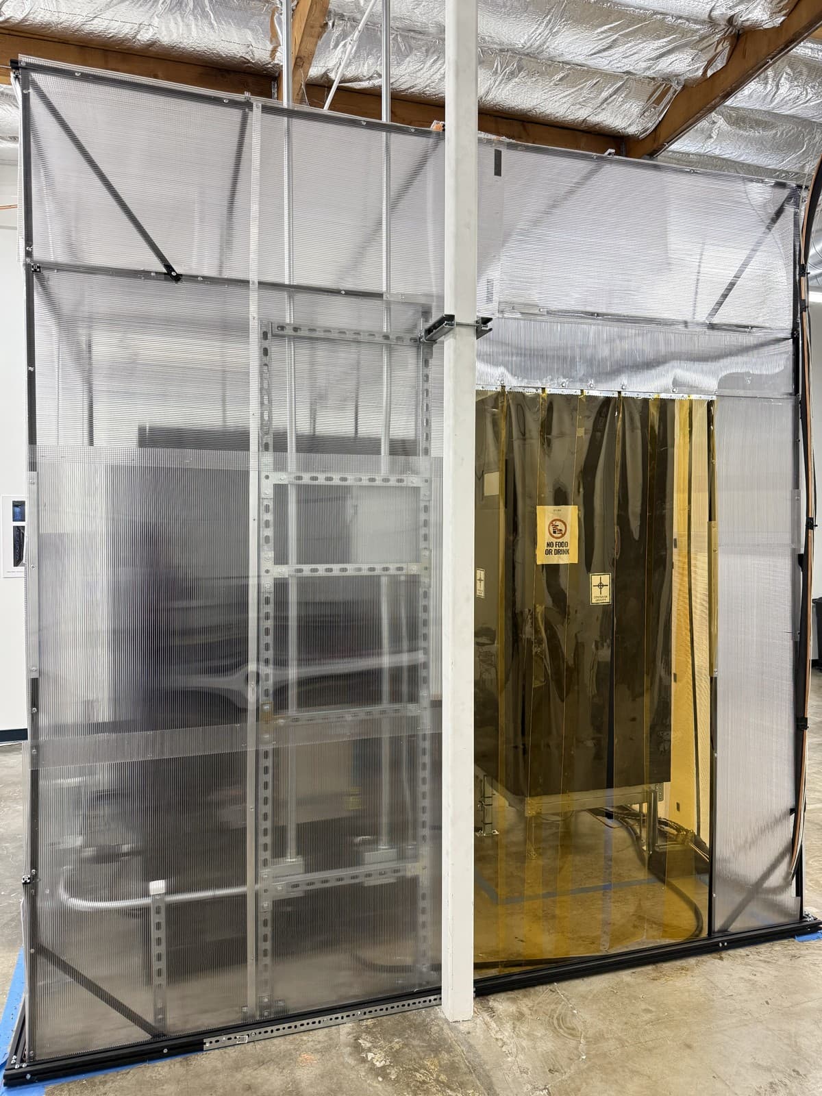 FLUIX lab containment with a cold-aisle flooded zone and an isolated hot-air return plenum inside a warehouse.