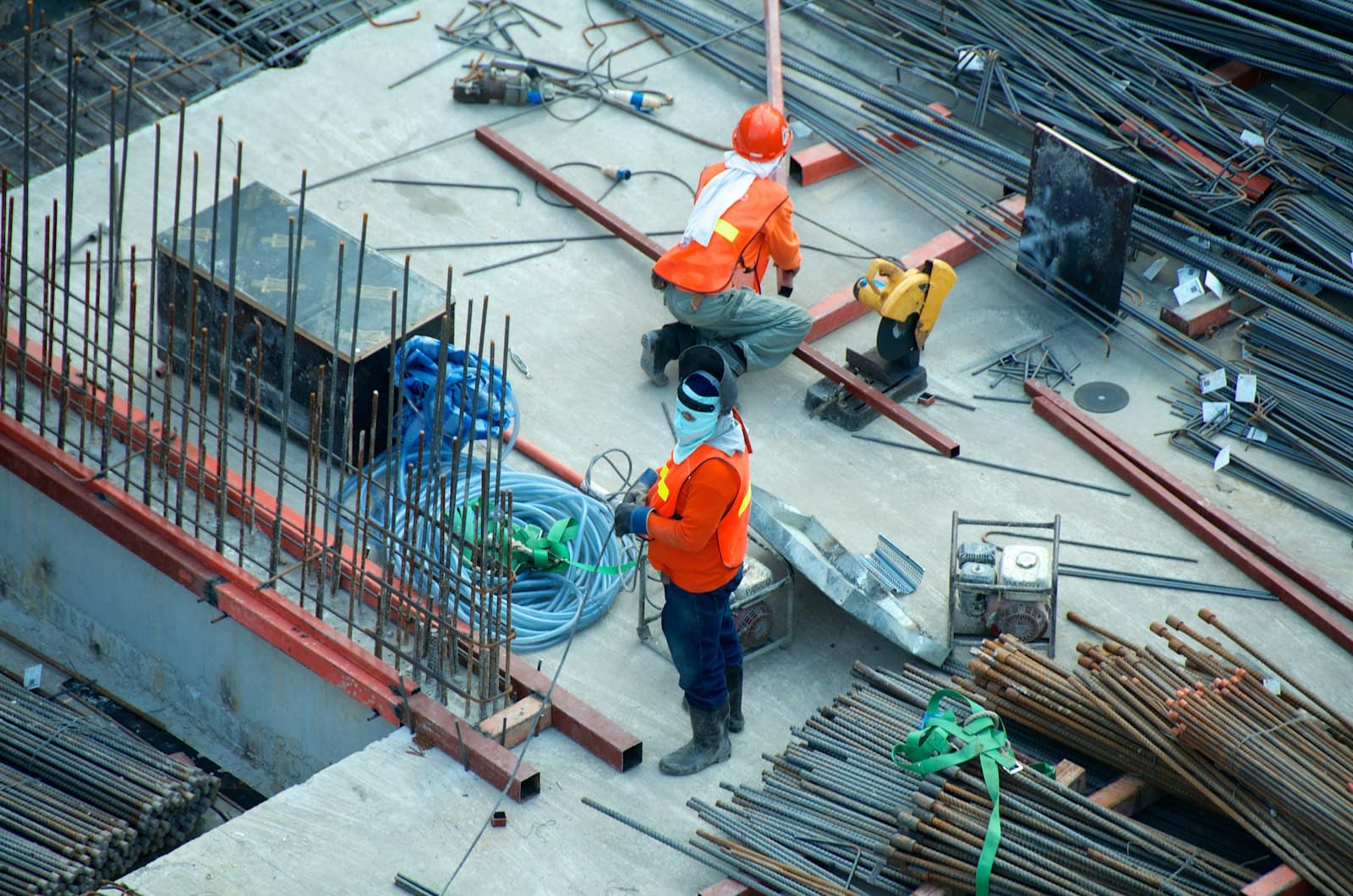 Construction workers placing rebar on a concrete deck